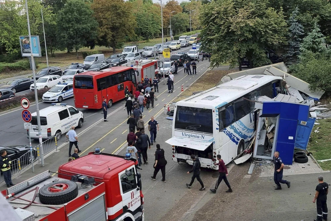 Police escort migrants to board a bus at the scene of an incident, where two police officers were killed. (Bulgarian News Agency via AP)