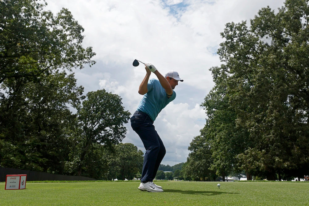 Scottie Scheffler hits his tee shot on the fifth hole during the first round of the Tour Championship golf tournament in Atlanta. (Atlanta Journal-Constitution via AP)
