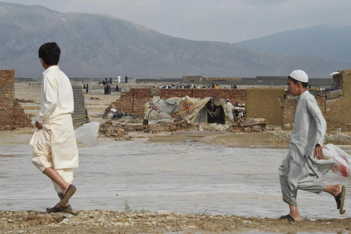 Children walk near a flood affected area after heavy monsoon rainfalls in Quetta on August 26, 2022. (AFP)