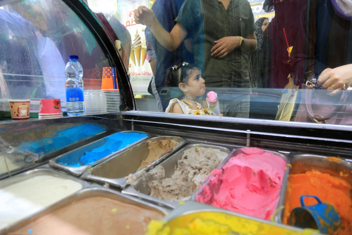 Palestinian girl eats ice cream in Kathem ice cream shop, as heat and lengthy power cuts melt ice cream shops' profits in Gaza. (Reuters)