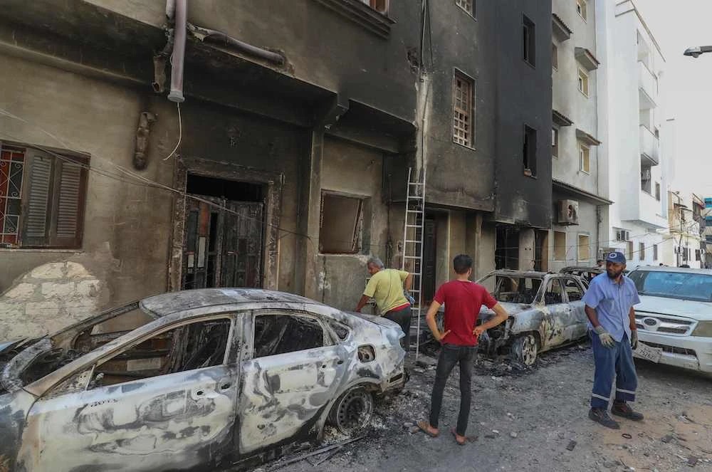 People inspect the damage following clashes between backers of rival governments in Libya's capital Tripoli, on August 28, 2022. (AFP)