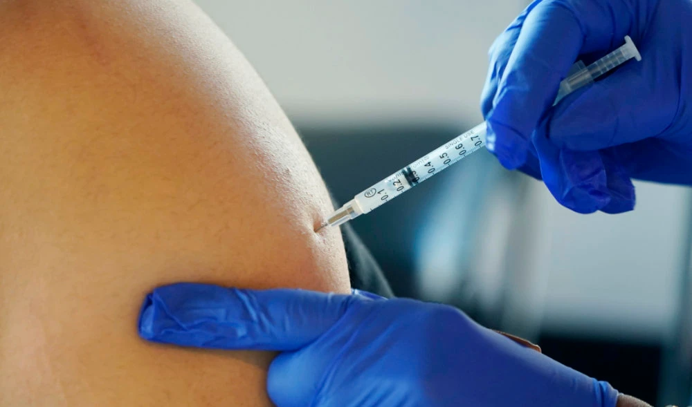 A resident receives a Pfizer booster shot from a nurse at a vaccination center. (AP)