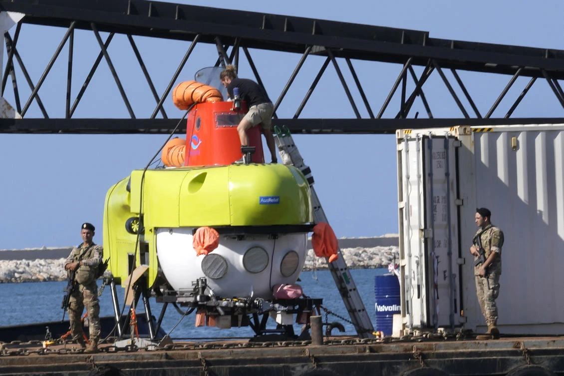 A technical member team of the small, 3-person underwater craft, a Pisces VI submarine, center top, checks the submarine at the Lebanese navy base, in Tripoli, north Lebanon. (AP)