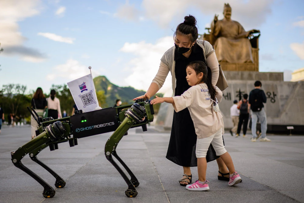 A young girl and her mother interact with a 'Robot Dog', made by Ghost Robotics, displayed for the public during an event at Gwanghwamun Square in Seoul. (AFP)