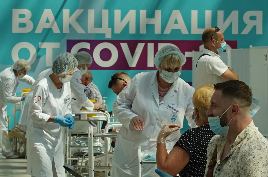People receive a vaccine against the coronavirus disease (COVID-19) at a a vaccination center in Moscow. (Reuters)