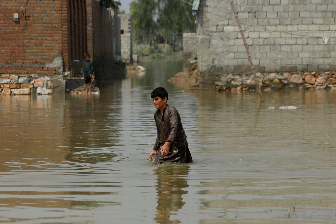 A boy makes his way through stranded flood water, following rains and floods during the monsoon season in Nowshera, Pakistan September 3, 2022. (Reuters)