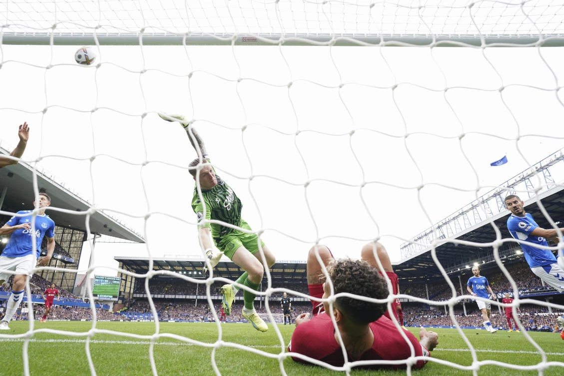 Everton's goalkeeper Jordan Pickford saves a ball as Liverpool's Roberto Firmino falls in the net during the English Premier League soccer match between Everton and Liverpool at Goodison Park. (AP)