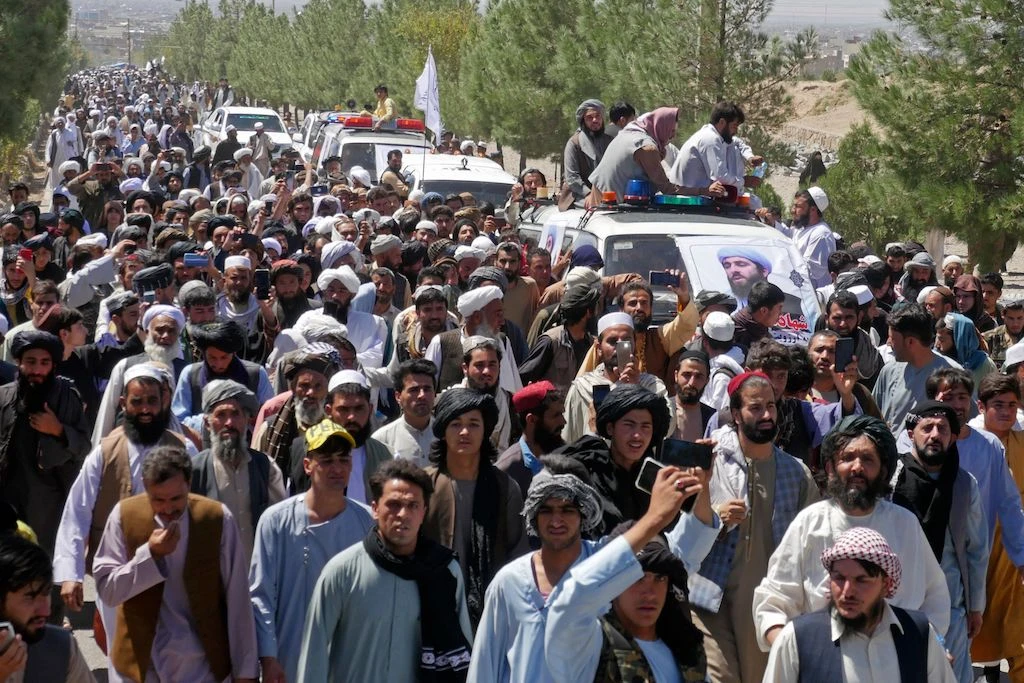 Mourners walk along as cars transport the coffin of imam Mujib ur Rahman Ansari, who was killed yesterday in a blast during the Friday prayer in Gazargah mosque, in Herat on September 3, 2022. (AFP)