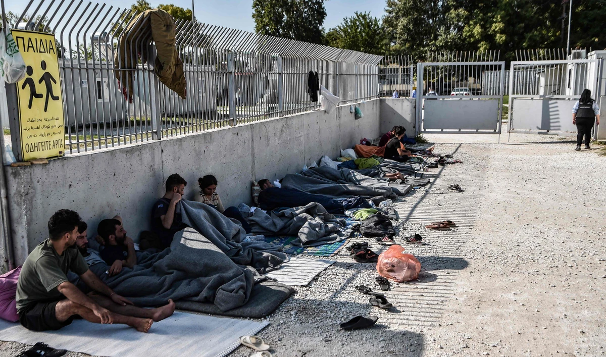Yazidi migrants from Iraq wait for the entry into a refugee camp in Serres, northern Greece, on September 6, 2022 as they have been stranded outside the camps in Serres for nearly 2 weeks. (AFP)