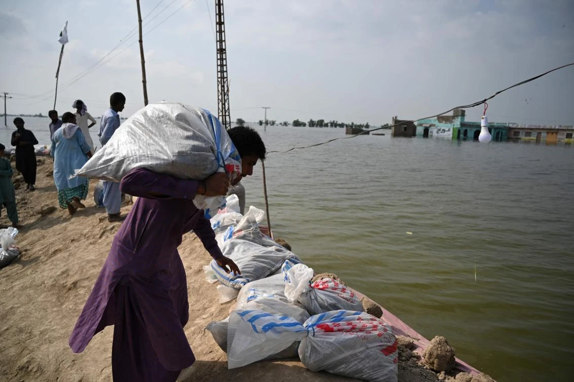 Residents place sand bags to prepare a wall to protect population from flood waters in Mehar area after heavy monsoon rains in Sindh province on Sept. 7, 2022. (AFP)