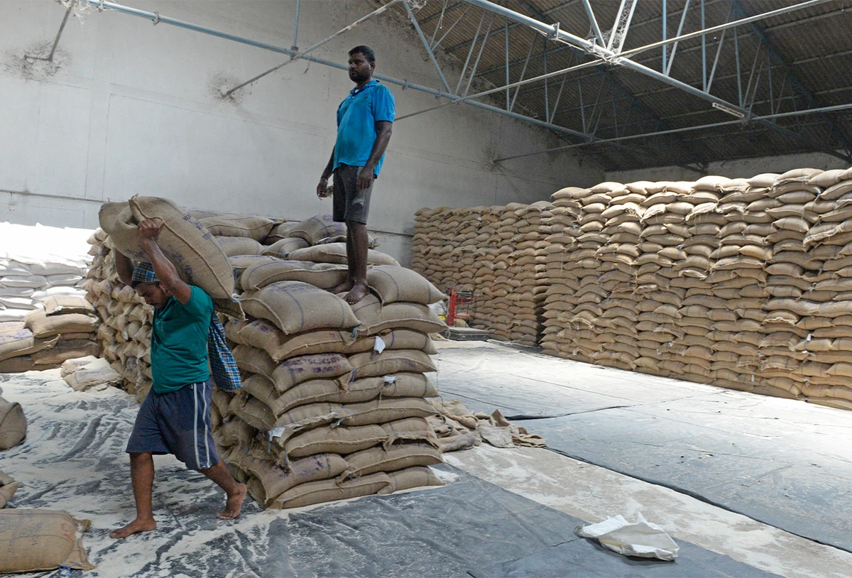 A labourer carries a rice sack from a civil supplies godown to load in a tranport vehicle for distribution in the districts of Telangana state in Hyderabad, India, on June 10, 2020. (AFP/File)