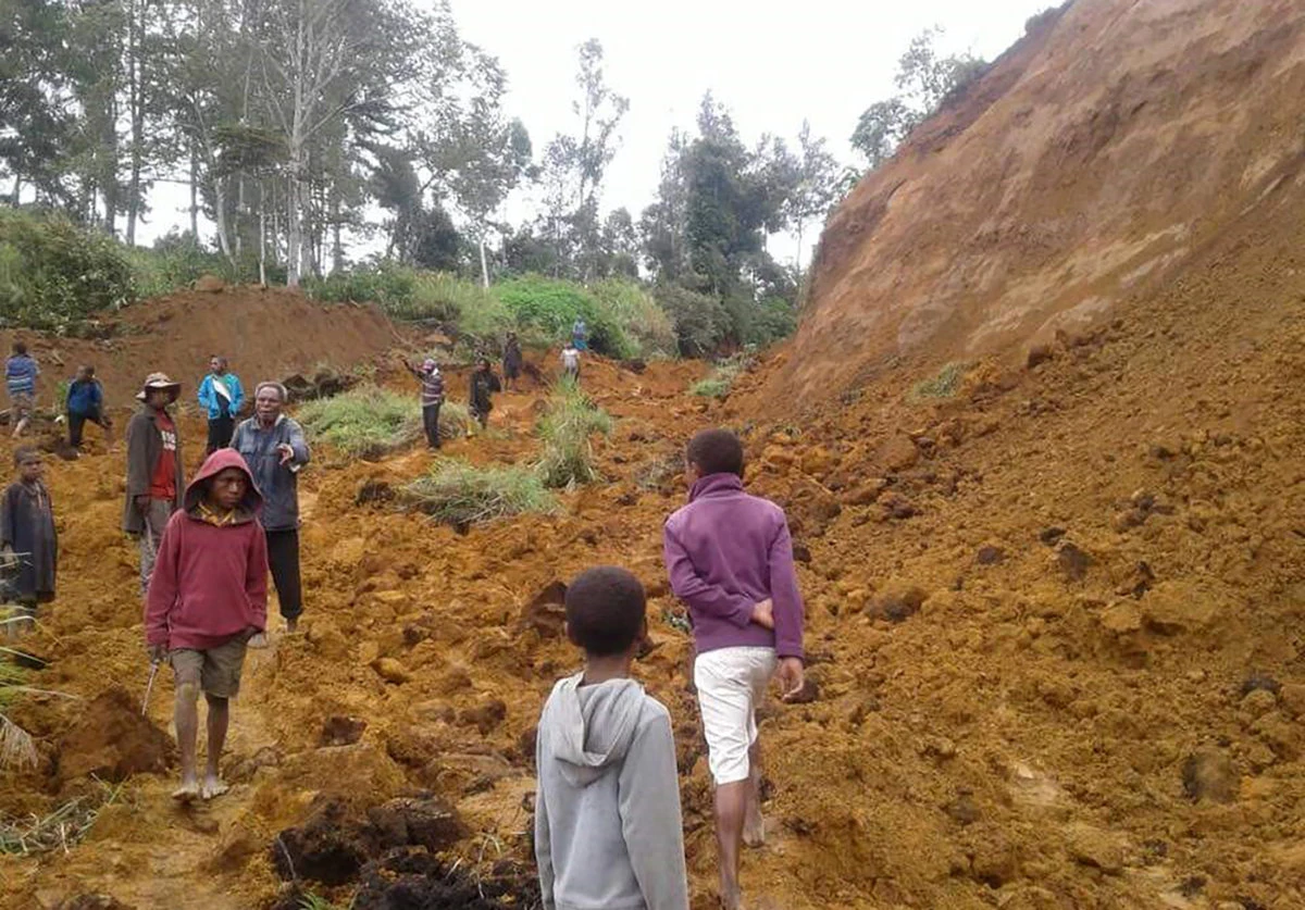 This photo taken on Feb. 27, 2018 shows people walking at the site of a landslide near the village of Ekari in Papua New Guinea's highlands region after a 7.5-magnitude earthquake. (AFP file)