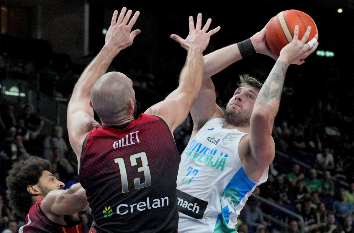 Slovenia's Luka Doncic, right, is challenged by Belgium's Pierre-Antoine Gillet, front, during their EuroBasket round of 16 match in Berlin on Sept. 10, 2022. (AP)