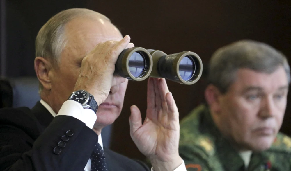 Russian President Vladimir Putin uses a pair of binoculars while watching the Zapad-2017 war games with Chief of the General Staff of Russian Armed Forces Valery Gerasimov seen nearby, in the Leningrad region, Russia Sept. 18, 2017. (REUTERS)