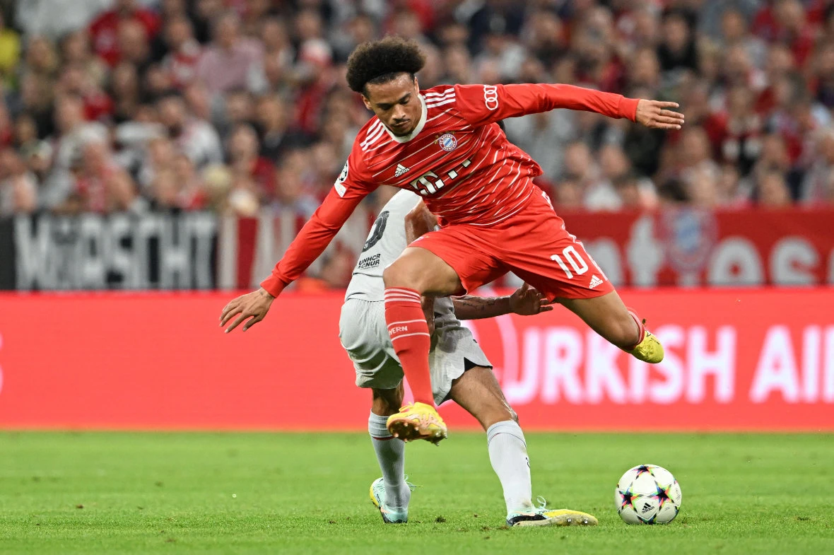 Bayern Munich's German midfielder Leroy Sane (front) and Barcelona's Spanish midfielder Sergio Busquets vie for the ball during the UEFA Champions League Group C football match between FC Bayern Munich and FC Barcelona in Munich on Sept. 13, 2022. (AFP)