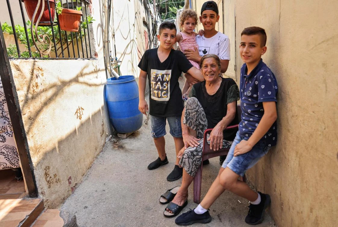 "Umm Abbas", 75, a survivor of Sabra massacre, poses with her grandchildren as she recounts her memories at the Sabra camp for Palestinian refugees in the southern suburbs of Beirut. (AFP)