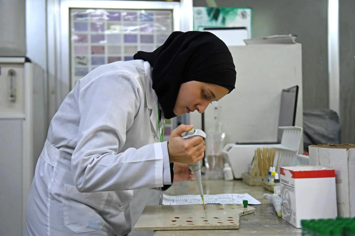 A lab technician works on samples to test for cholera, at a hospital in Syria's northern city of Aleppo. (AFP)