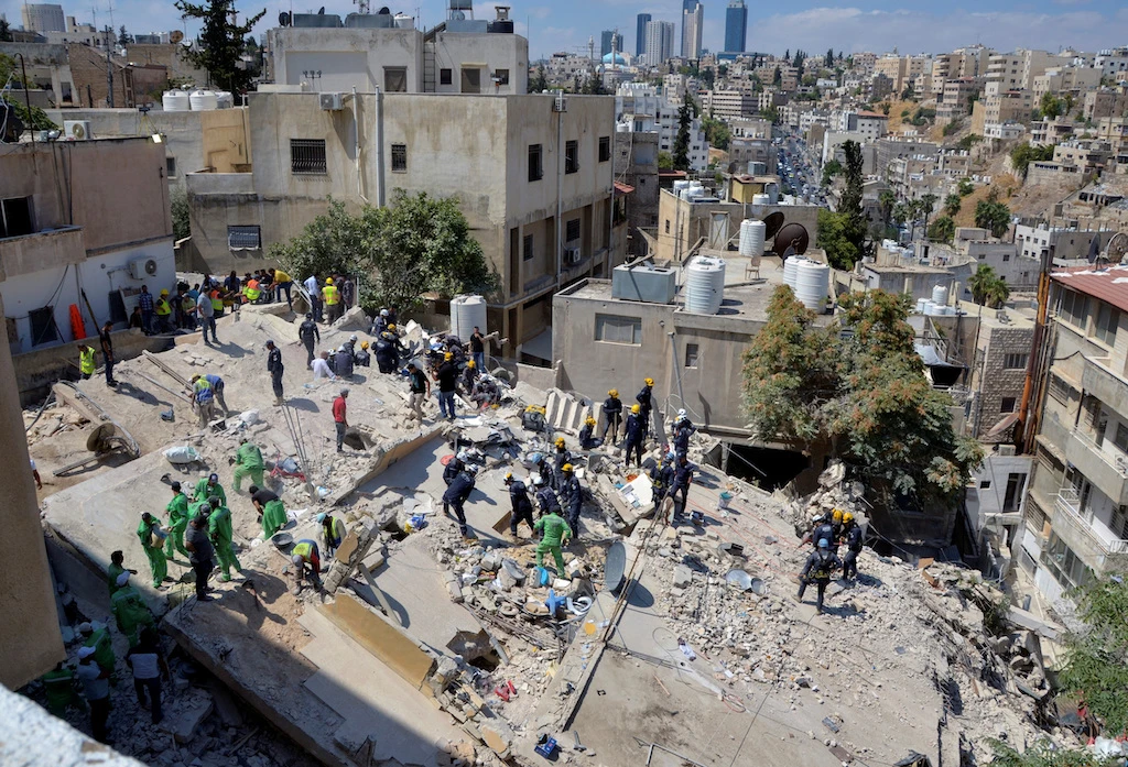 Rescuers search for survivors under the rubble of a collapsed building in Amman. (File/Reuters)