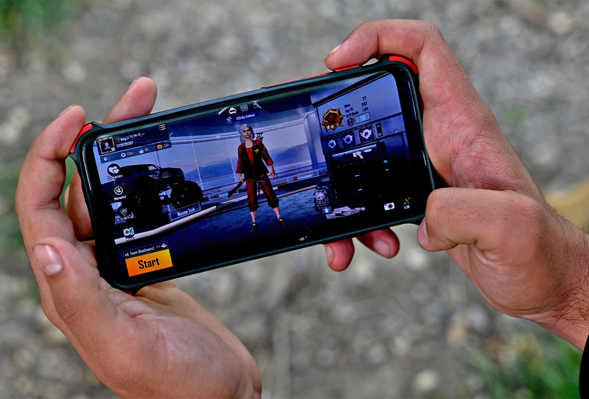 An Afghan youth plays PUBG game on his mobile phone at a park in Kabul, Afghanistan, on April 21, 2022. (AFP)