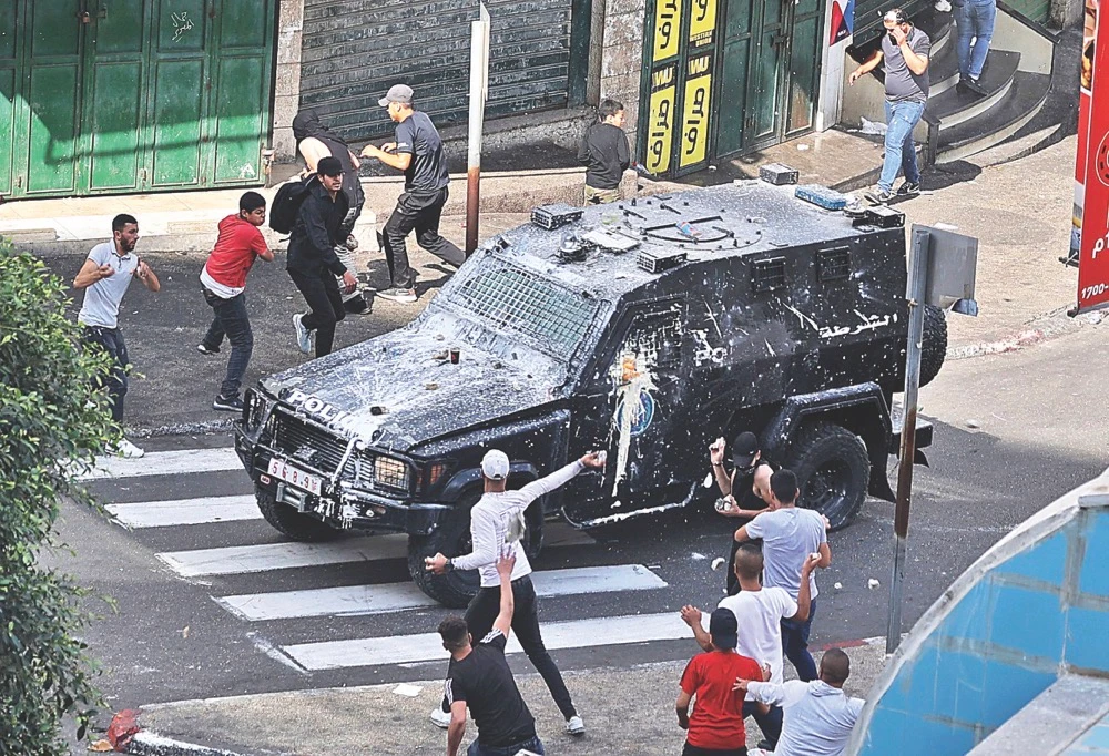 Protesters clash with Palestinian security forces in Nablus in the occupied West Bank on Tuesday following the arrest of two members of Hamas. AFP