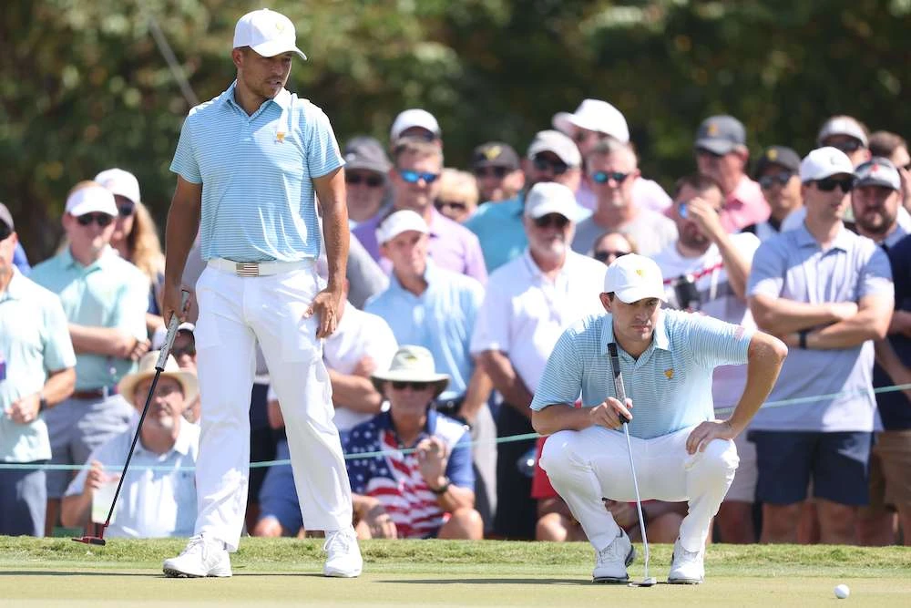 Xander Schauffele, left, and teammate Patrick Cantlay of the US team line up a putt at the 2022 Presidents Cup on Sept. 22, 2022 in Charlotte, North Carolina. (AFP)