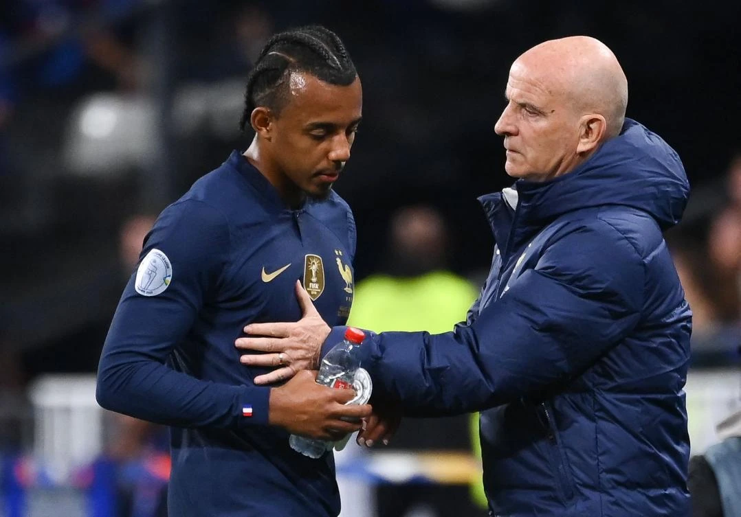 France’s defender Jules Kounde is consoled by France’s assistant coach Guy Stephan after he was injured during their UEFA Nations League match against Austria at Stade de France in Saint-Denis on Thursday. (AFP)
