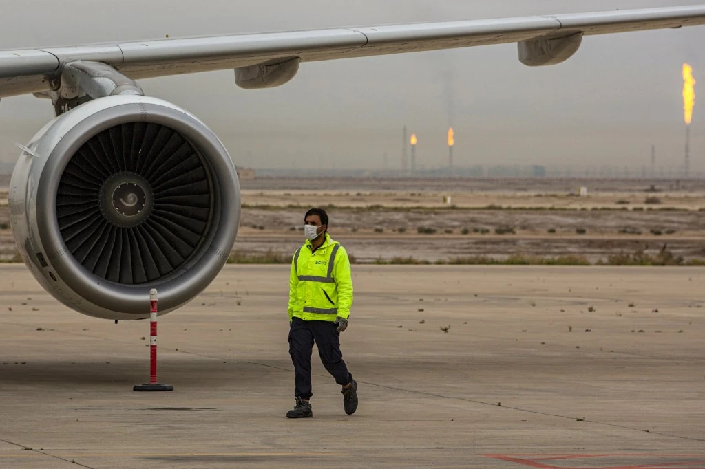 A worker at Basra International Airport walks past a plane engine. (File/AFP)