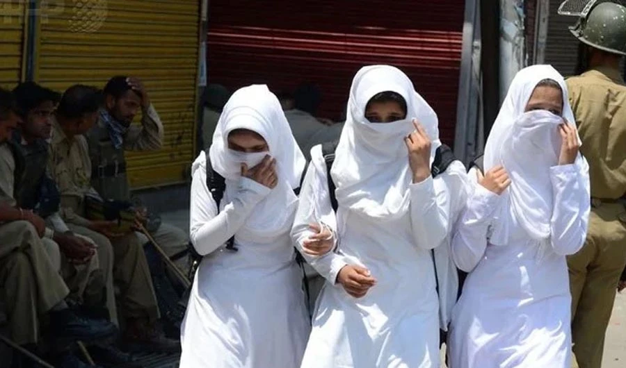 Kashmiri schoolgirls walk past Indian policemen in Srinagar, Jammu and Kashmir. (AFP)