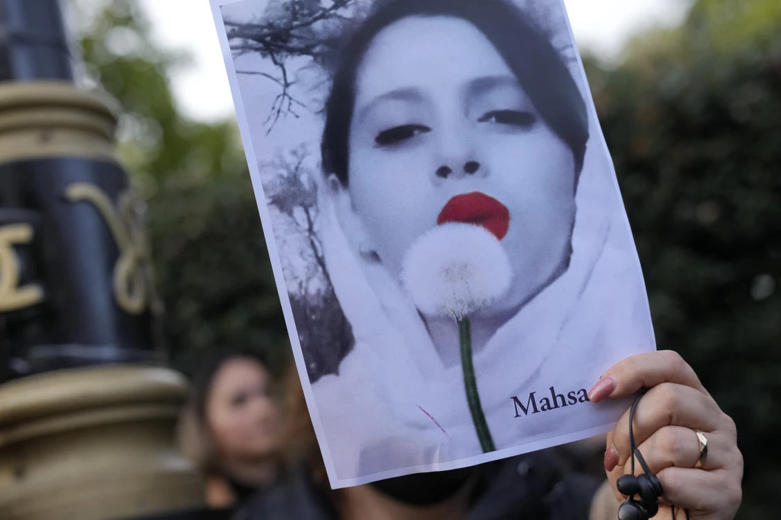 Demonstrators hold placards outside the Iranian Embassy in London, Sunday, Sept. 25, 2022. (AP)