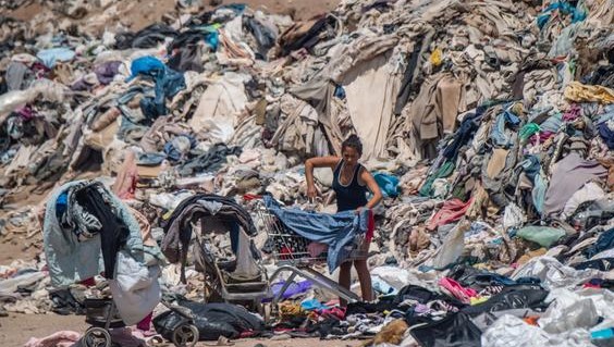 A woman sifts through used and unused clothing in Chile’s Atacama Desert. (AFP)