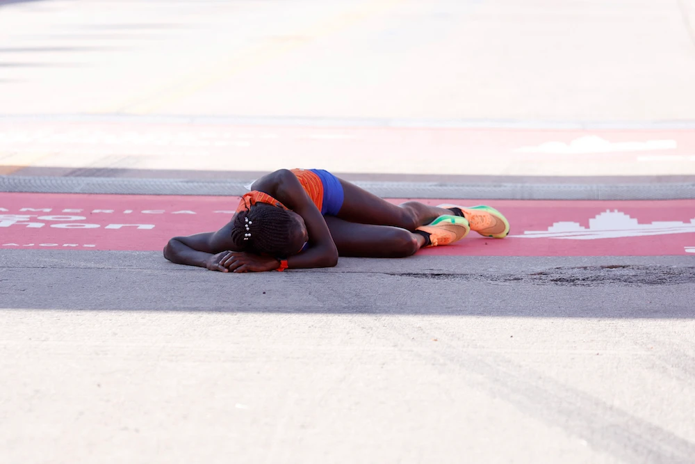 Kenya's Vivian Kiplagat collapses at the finish line after placing third in the women's division of the 2022 Bank of America Chicago Marathon in Chicago, Illinois, on October 9, 2022. (AFP)