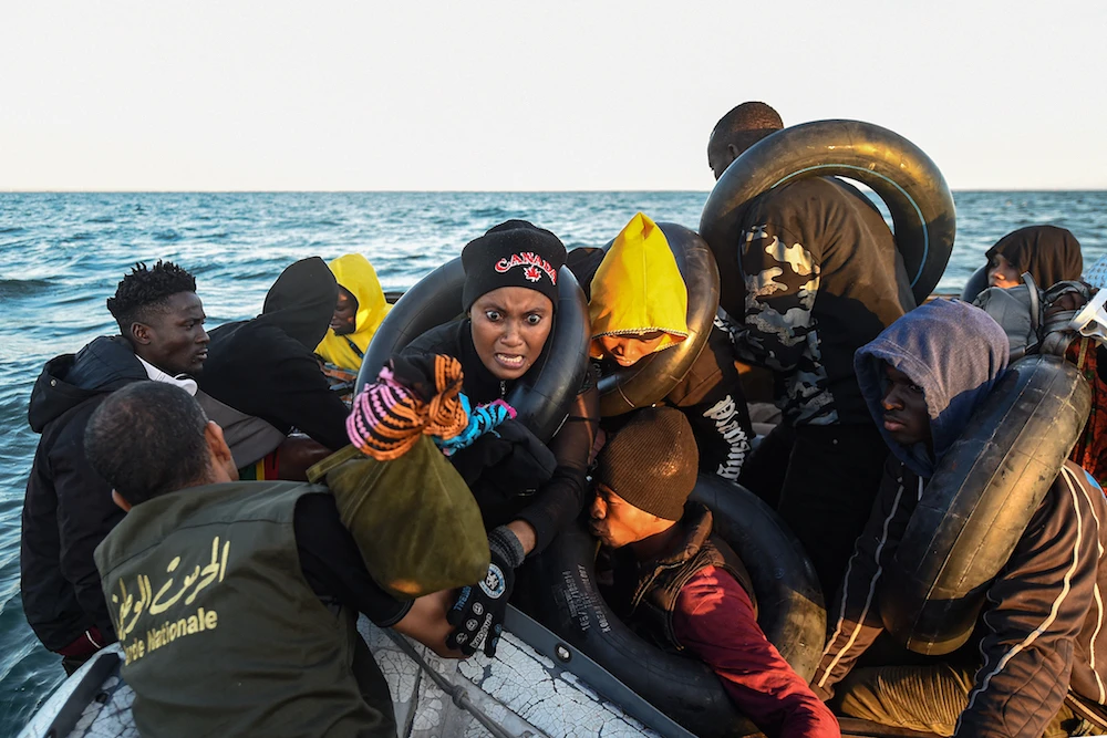 Migrants from sub-Saharan Africa sit in a makeshift boat that was being used to clandestinely make its way towards the Italian coast. (AFP)