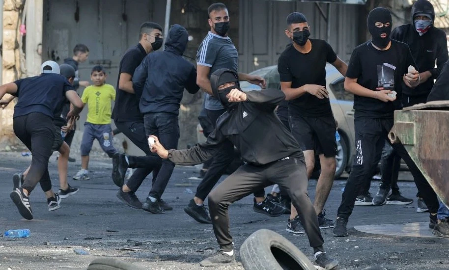 Palestinian protesters throw stones at Israeli security forces in Shuafat refugee camp, east Jerusalem, Oct. 10, 2022. (AFP)