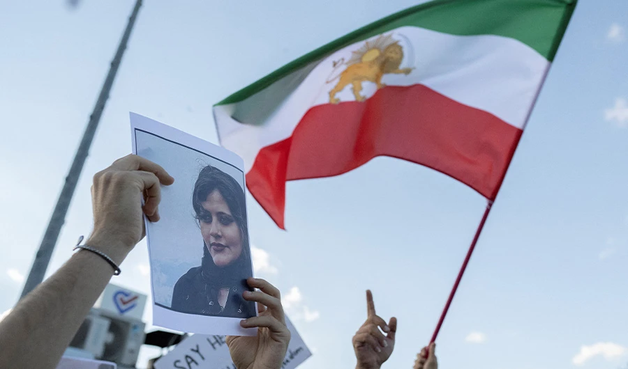 A protestors holds a photo of Kurdish Iranian woman Mahsa Amini as another waves Iran's former flag during a demonstration against the Iranian regime and in support of Iranian women, after Amini died after being arrested in Tehran by the Islamic Republic's morality police, in Istanbul on October 2, 2022. (AFP)