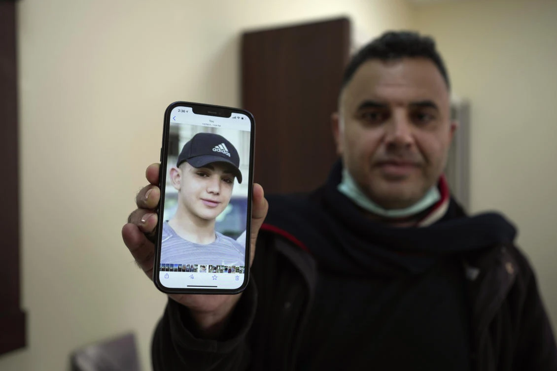Muamar Nakhleh, father of Amal Nakhleh, a Palestinian teen with a rare neuromuscular disorder, who had been held without charge for a year, shows his photo at his office in the West Bank. (File/AP)