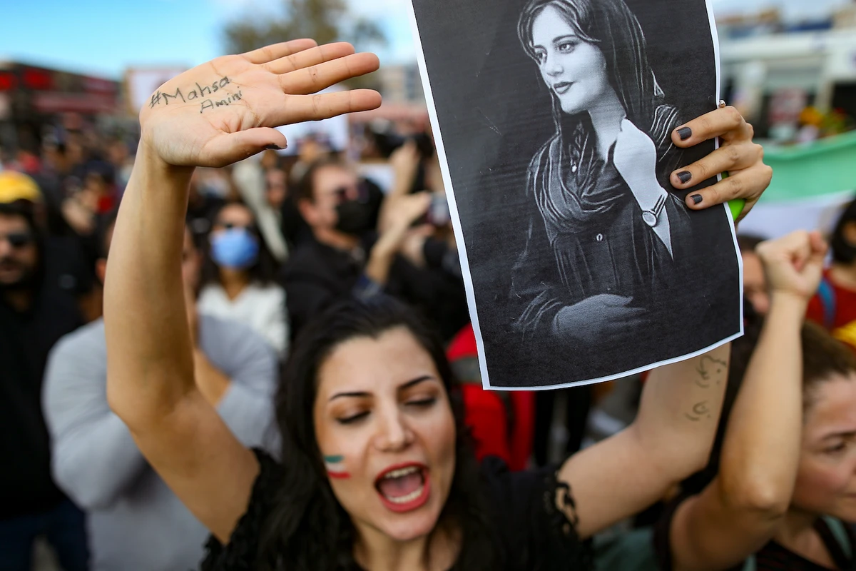 A woman holds up a drawing of Iranian Mahsa Amini as she shouts slogans during a protest against her death, in Istanbul, Turkey, Sunday, Oct. 2, 2022. (AP)
