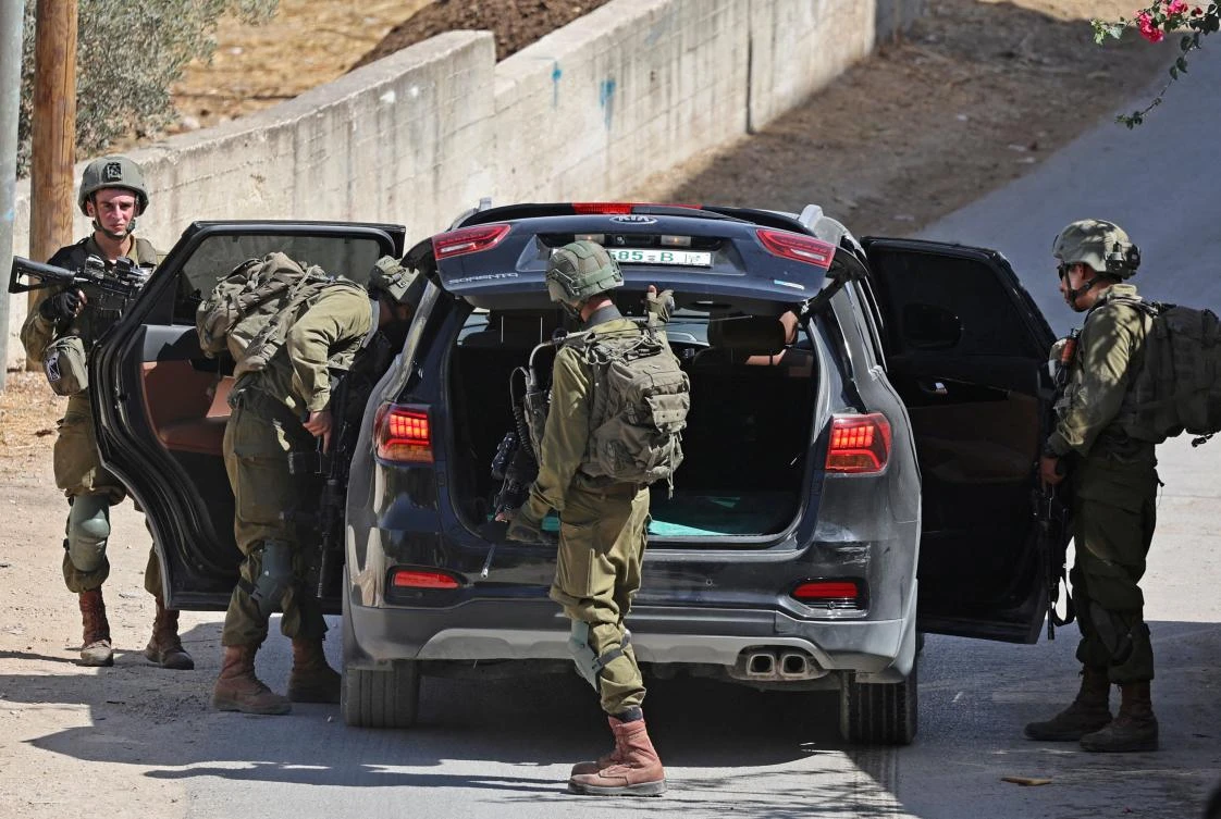 Israeli security forces search a vehicle in the village of Salem, east of Nablus on Oct. 2, 2022. (AFP)