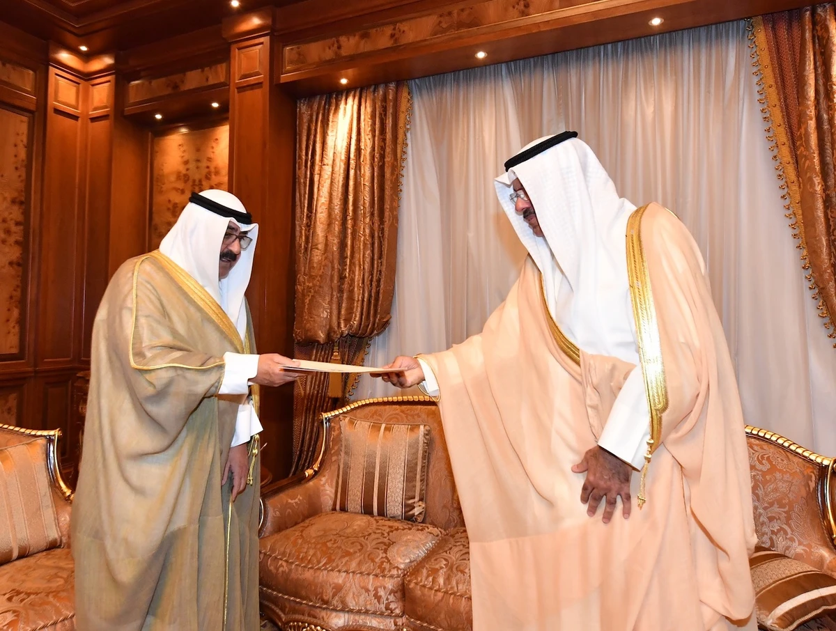 Prime Minister Sheikh Ahmad Nawaf Al-Ahmad Al-Sabah (R) presents a list of new cabinet members to Kuwait's Crown Prince Sheikh Mishal Al-Ahmad Al-Jaber Al-Sabah. (Kuwait News Agency)