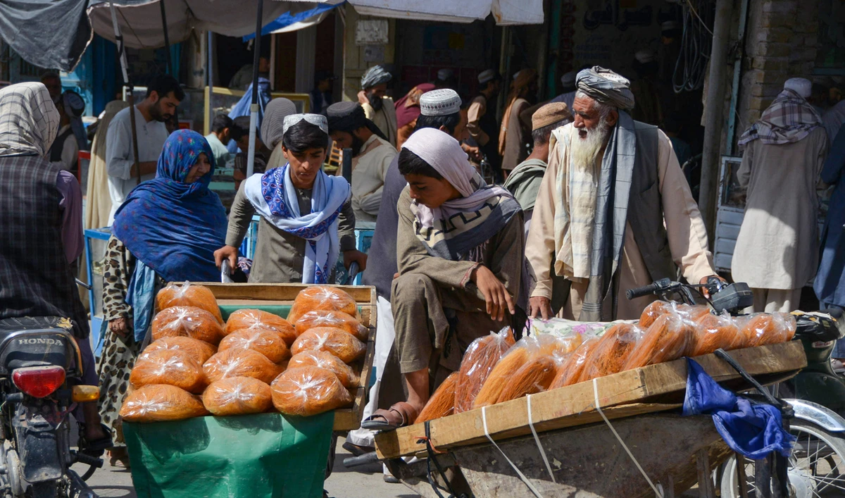 Afghan boys sell bread on a wheelbarrow at second district in Kandahar, on August 4, 2022. (AFP/File)