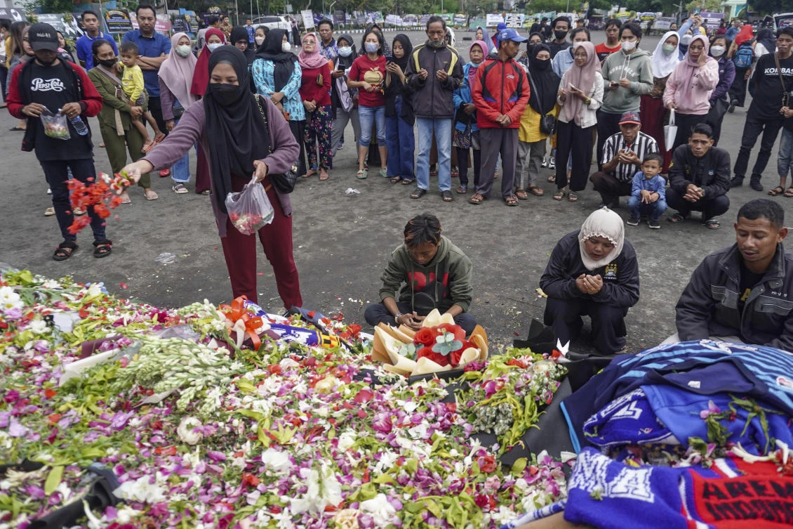 A woman throws flowers as she and others offer prayers for the victims of Saturday's soccer stampede outside the Kanjuruhan Stadium in Malang, East Java, Indonesia, Wednesday, Oct. 5, 2022. (File/AP)