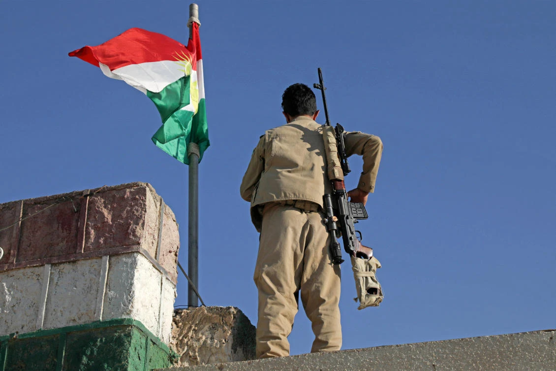 A Kurdish peshmerga fighter affiliated with the Iranian Kurdistan Democratic Party (KDP-Iran) stands guard on a building following an Iranian cross-border attack in the town of Koye (Koysinjaq). (File/AFP)