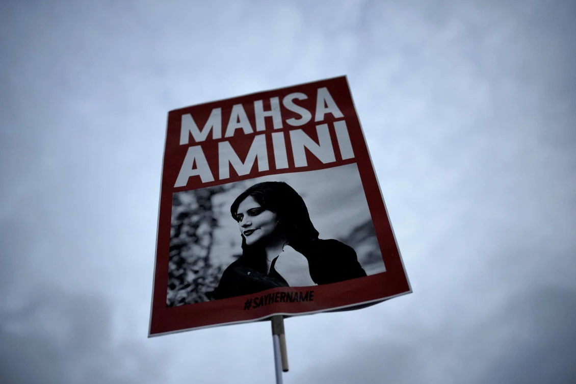 FILE - A woman holds a placard with a picture of Iranian Mahsa Amini as she attends a protest against her death, in Berlin, Germany, Wednesday, Sept. 28, 2022. Nasreen Shakarami, the mother of Amini, said Friday, Oct. 7, the teen was killed by repeated blows to the head as part of Iran's crackdown on anti-hijab protests roiling the country. Shakarami also said authorities kept her daughter Nika’s death a secret for nine days and then snatched the body from a morgue to bury her in a remote area, against the family’s wishes. (AP Photo/Markus Schreiber)