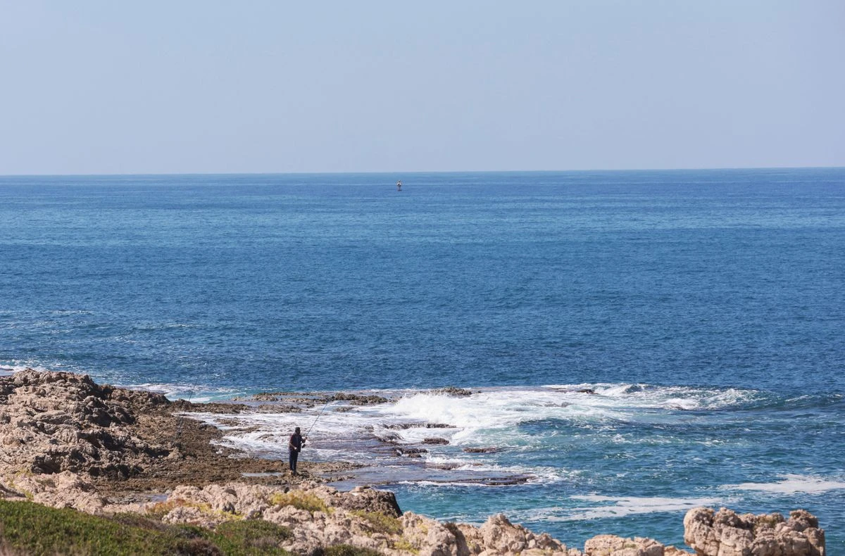 A fisherman dangles his line to catch fish, in Naqoura, near the Lebanese-Israeli border, southern Lebanon. (File/Reuters)