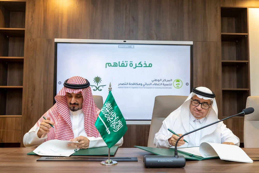 Bandar Al-Qahtani, Executive Director of the Camel Club (Left) and Khalid Al-Abdul Al-Qadir, National Center for Vegetation Development and Combating Desertification, signing an agreement in Riyadh on Tuesday to plant 500,000 trees in Al-Sayahid Area, northeast Riyadh, which is frequented by owners of camels. (Camel Club/Supplied)