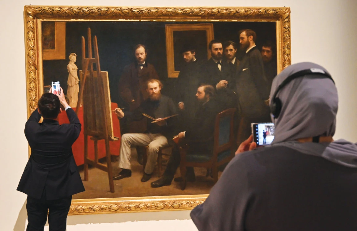 Visitors look at Henri Fantin-Latour’s masterpice ‘A Studio at Les Batignolles’ at the Louvre Museum in Abu Dhabi. (AFP)