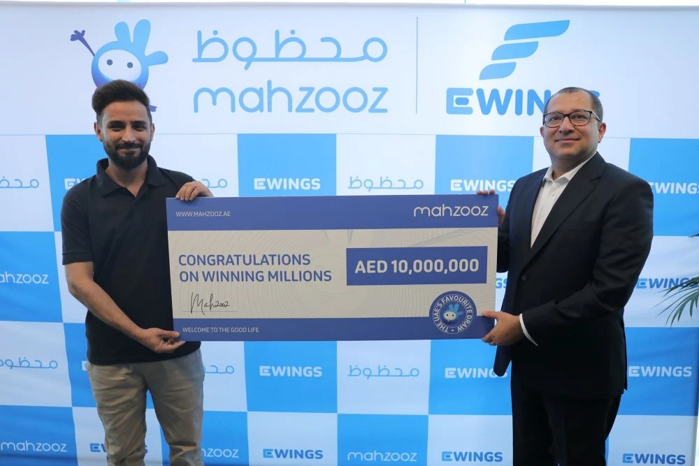 Pakistani mechanic Saad Sultan, left, receives a cheque of AED 10 million after winning the weekly Mahzooz draw on Oct. 6, 2022, in the United Arab Emirates. (Courtesy: Mahzooz)