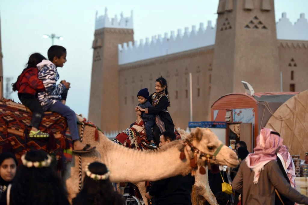 Saudi children ride camels during a festival of heritage and culture held in the Saudi village of Al-Thamama. (File/AFP)