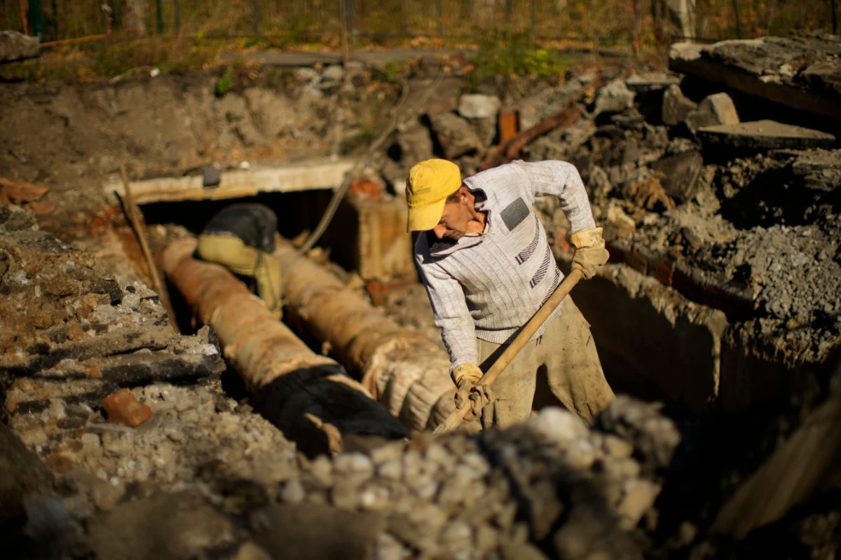 Workers repair central heating infrastructure in Saltivka residential district in Kharkiv, Ukraine, as temperatures drop below freezing. (AP Photo/Francisco Seco)
