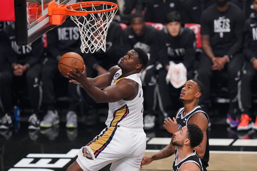 New Orleans Pelicans’ Zion Williamson, left, drives past Brooklyn Nets’ Nic Claxton, top right, and Ben Simmons during the first half of their NBA basketball game Wednesday in New York. (AP)