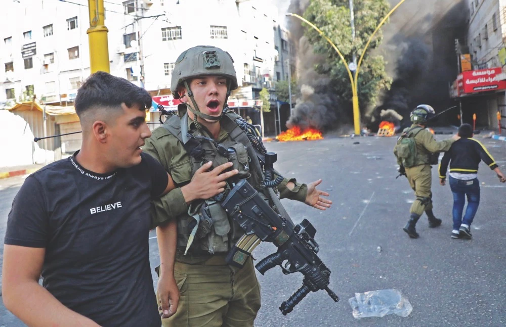 Israeli soldiers detain Palestinian youths during clashes in the flashpoint city of Hebron in the occupied West Bank on Thursday. (AFP)